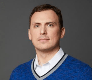 Jonathan Tomek, VP of Research and Development at Digital Element, has light brown hair and eyes, wearing a blue sweater.