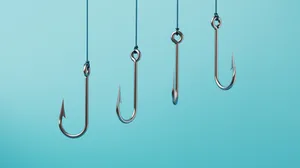 Three fishing hooks against a light blue background. Three fishing hooks against a light blue background.