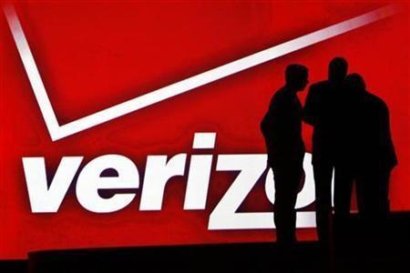 silhouetted people against red verizon logo backdrop