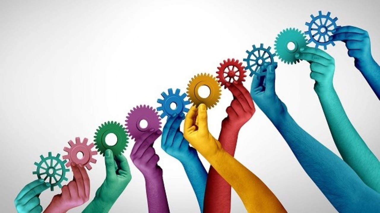 Hands of different colors turning the gears together Hands of different colors turning the gears together