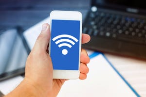 Wireless Internet symbol on a cellphone being held in a hand