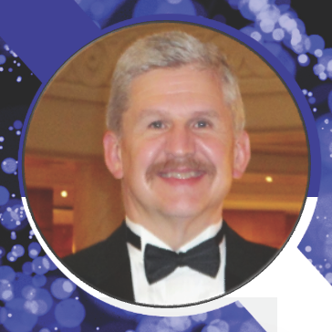 Patrick Barnett, Principal Consultant at Secureworks, has short graying hair and a mustache. He smiles, wearing a tuxedo.