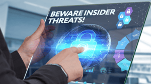 Hands of a person in a suit jacket holding a screen pointing to an image of a padlock and the words "insider threat" Hands of a person in a suit jacket holding a screen pointing to an image of a padlock and the words "insider threat"