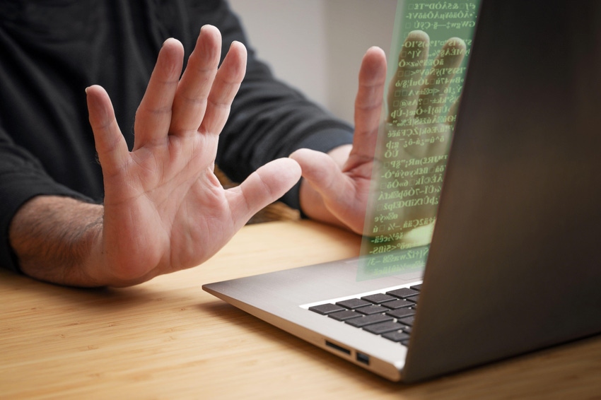 A user with their hands off a laptop keyboard and the screen image visibly away from the laptop