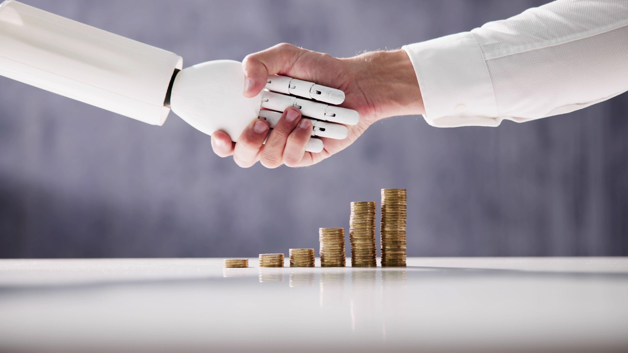 Robot and human shaking hands with coins stacked in the background  Robot and human shaking hands with coins stacked in the background