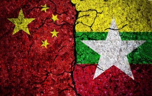 The Chinese and Myanmar flags on rubble, crumbling apart
