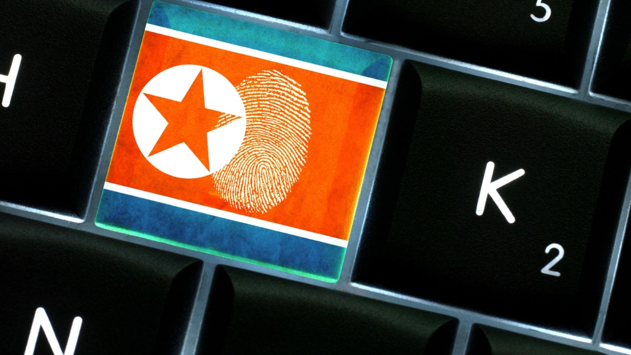 Black computer keyboard with white letters with a red and white North Korea flag and a fingerprint on one key between the letters H and K Black computer keyboard with white letters with a red and white North Korea flag and a fingerprint on one key between the letters H and K