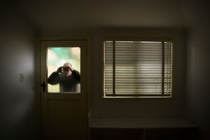A man looking through back door window