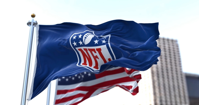 Flag with the NFL logo waving in the wind with the US flag blurred in the background