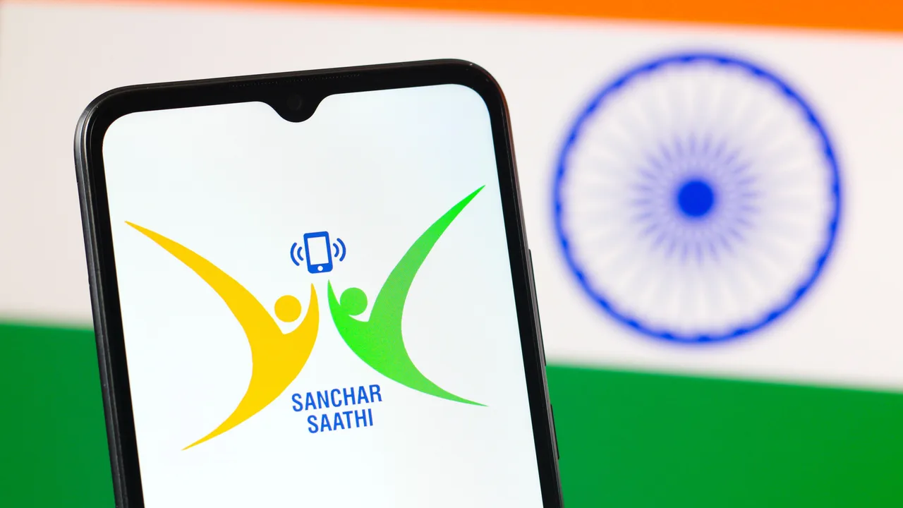 インド国旗を背景に、スマートフォン画面に表示されたSanchar Saathiアプリのロゴ インド国旗を背景に、スマートフォン画面に表示されたSanchar Saathiアプリのロゴ