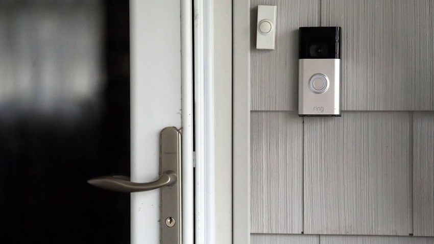 A ring doorbell camera in front of a house beside the front door 