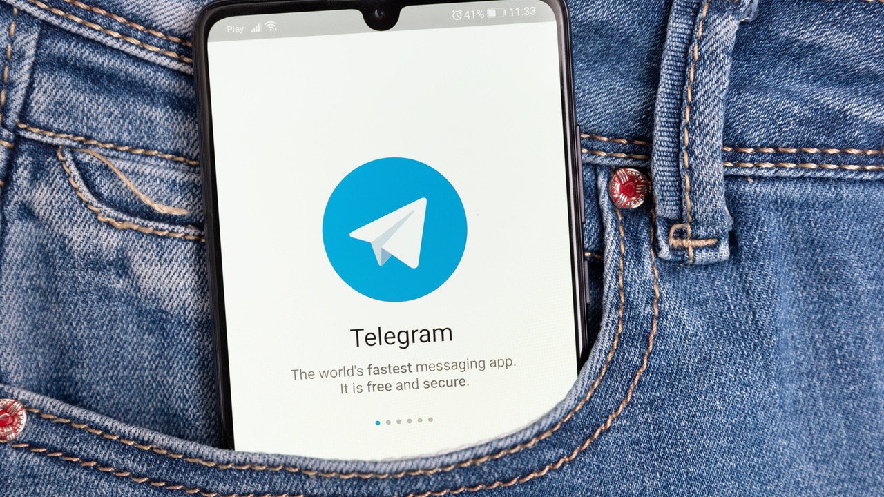 Mobile device in pocket with Telegram app displayed Mobile device in pocket with Telegram app displayed