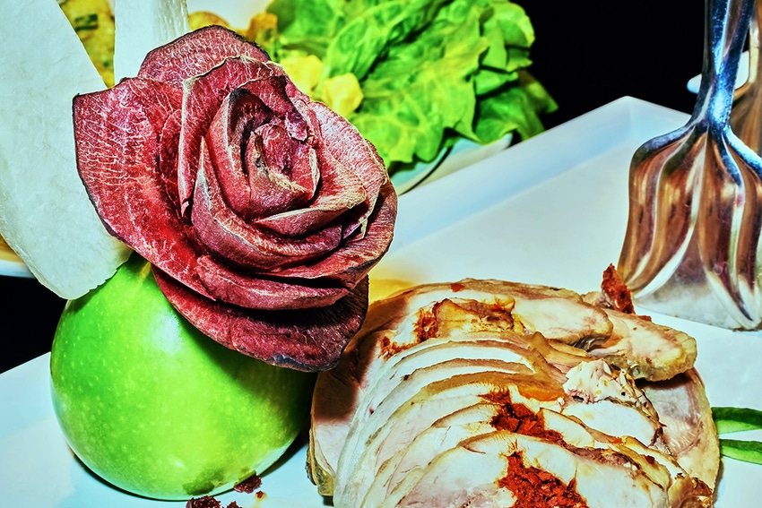 A roast turkey dinner with a garnish of a rose made out of beet slices