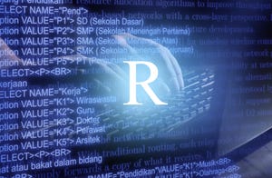 R programming language inscription against laptop keyboard and code background
