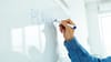 A hand writing on a white board. A hand writing on a white board.