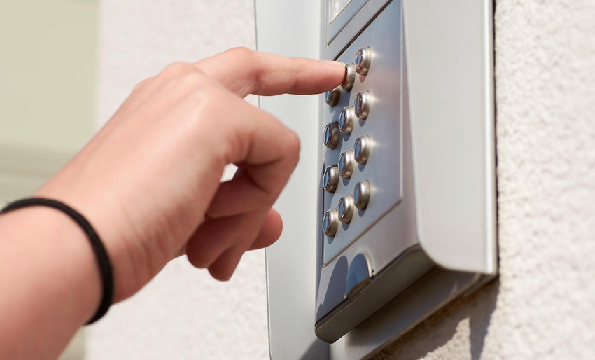 A person pressing the button on an intercom