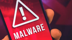Mobile phone in someone's hand with the screen showing the word malware and a triangle with an exclamation point inside it Mobile phone in someone's hand with the screen showing the word malware and a triangle with an exclamation point inside it