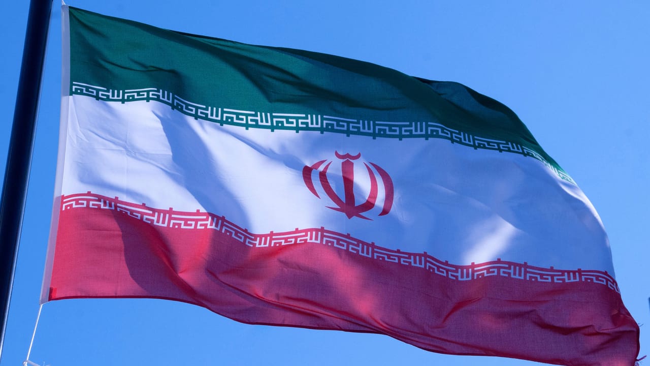 青空を背景に旗竿で揺れるイランの国旗 青空を背景に旗竿で揺れるイランの国旗