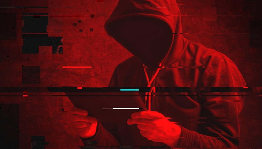 Hooded figure with face shrouded in black holding a tablet device against a red background 