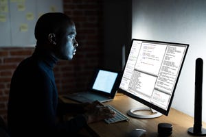 A black man sitting at a computer screen