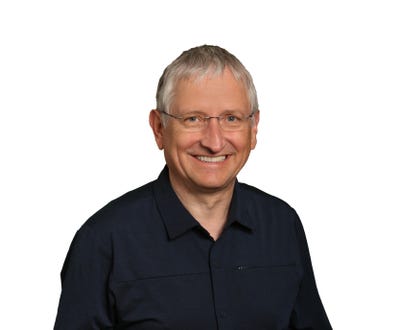 White man with short-cropped hair and black shirt.