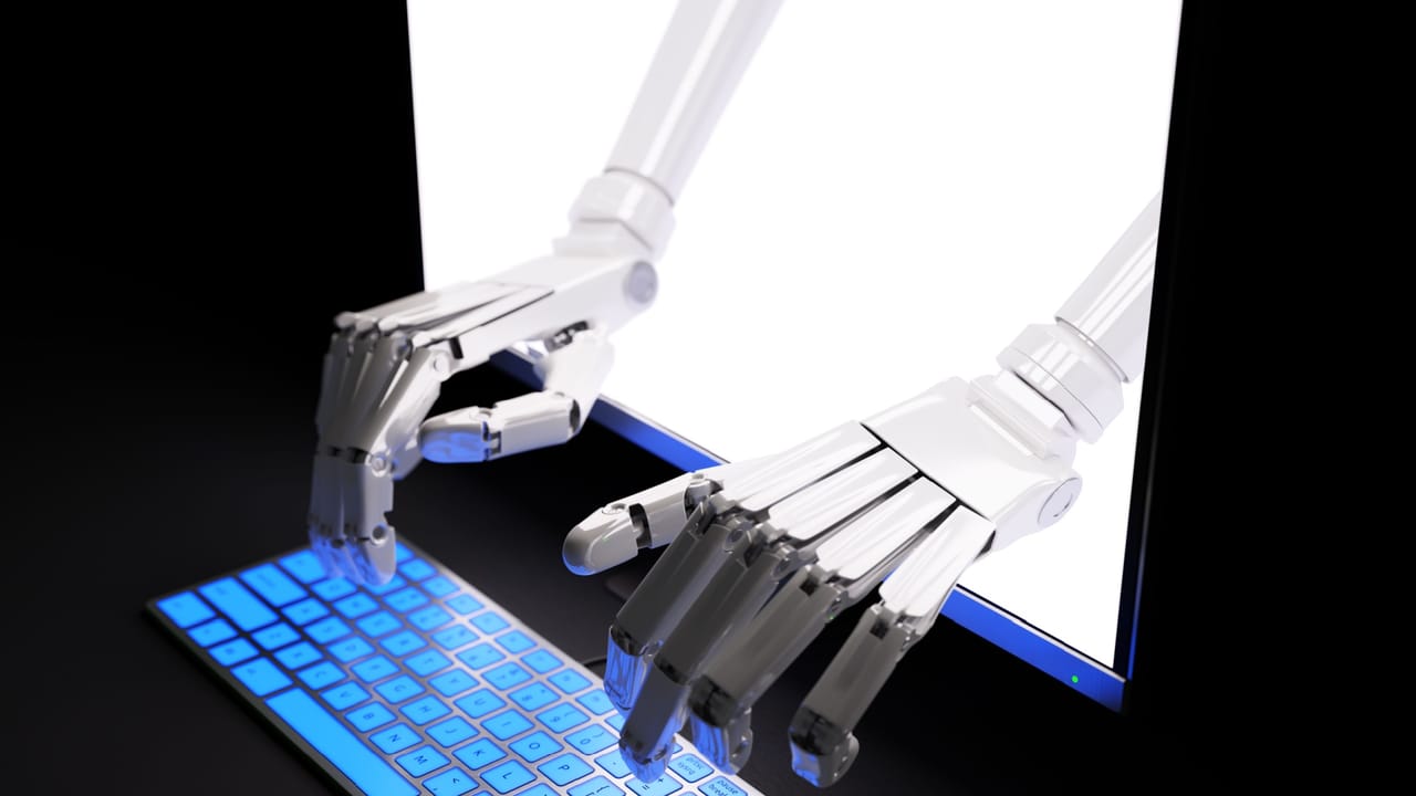 コンピュータ画面越しにキーボードを打つロボットの手 コンピュータ画面越しにキーボードを打つロボットの手