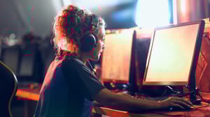 A focused teenage girl gamer wearing headphones and looking at PC screen. A focused teenage girl gamer wearing headphones and looking at PC screen.