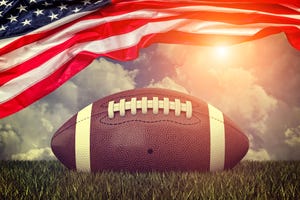An american football ball against us flag and blue sky