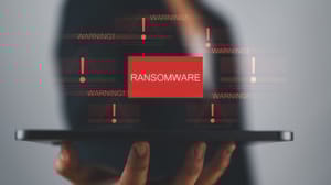 Concept illustration showing person using a tablet with virtual warning about ransomware Concept illustration showing person using a tablet with virtual warning about ransomware