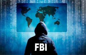 A figure in a FBI hoody sitting in front of a world map