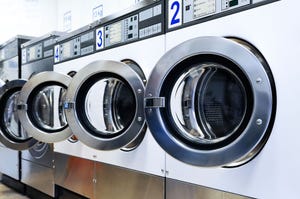 Row of open laundromat washing machines