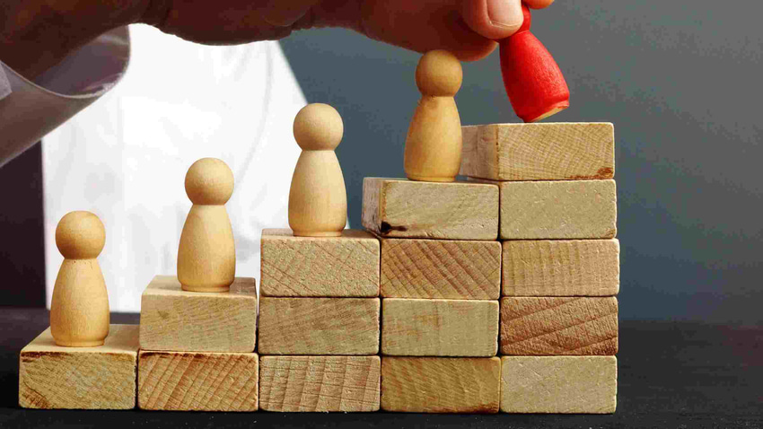 Hand holding a figurine up at the top of the career ladder. Hand holding a figurine up at the top of the career ladder.