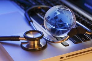 A stethoscope circling a digital globe on top of a laptop keyboard