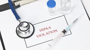 "HIPAA Violation" written on a form, surrounded by medical supplies "HIPAA Violation" written on a form, surrounded by medical supplies