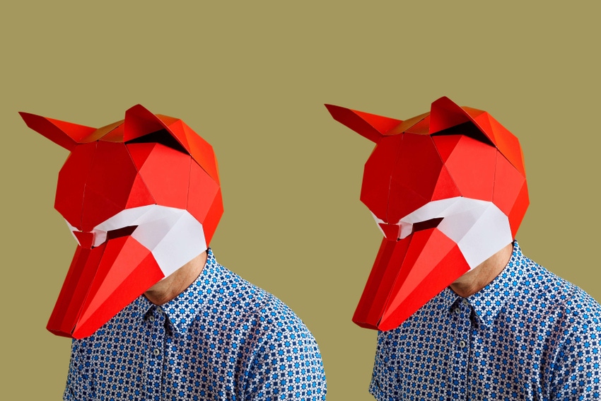 Photo of two young white men wearing identical red and white fox masks and patterned blue shirts on a yellow background