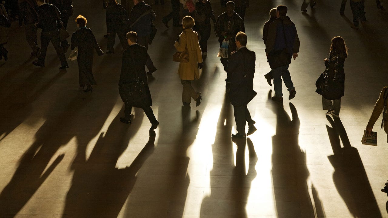 Businesspeople cast long shadows during morning rush hour inside Grand Central Station