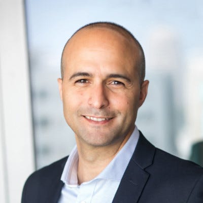Noam Shaar, co-founder and CEO of Wing Security, has a shaved head and wears an open collared shirt under a dark blazer