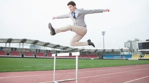 A businessman jumping over a hurdle A businessman jumping over a hurdle