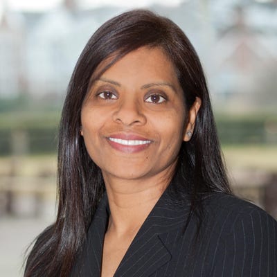 Shamla Naidoo, Head of Cloud Strategy & Innovation at Netskope, has long black hair and wears a black pinstriped jacket