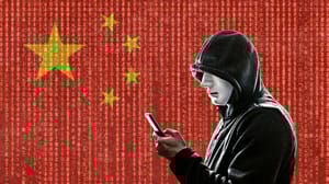 A person in a hoodie, holding a phone, in front of a Chinese flag A person in a hoodie, holding a phone, in front of a Chinese flag