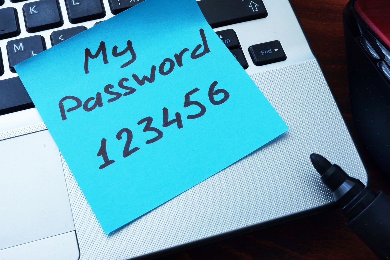 パスワードが書かれた付箋がキーボードの上に置かれている パスワードが書かれた付箋がキーボードの上に置かれている