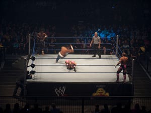 Two wrestlers in a tag-team wrestling match as referee looks on