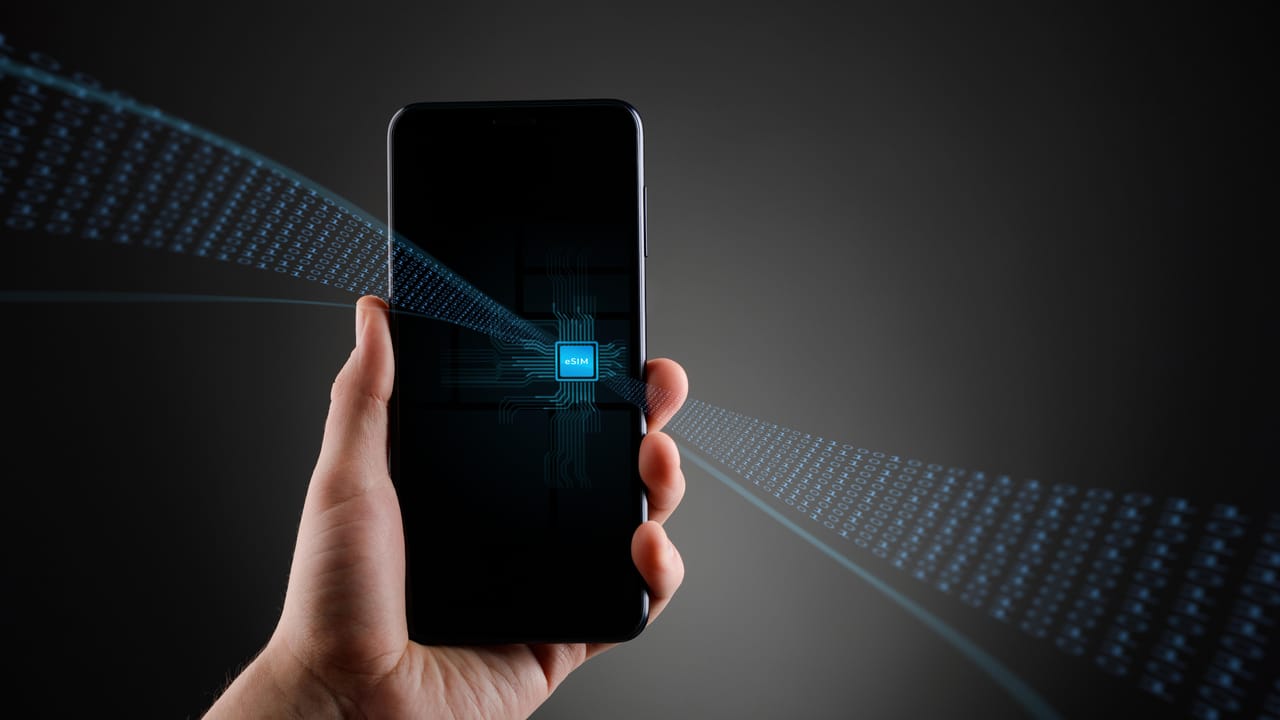 A smartphone with a graphic of an eSIM on it A smartphone with a graphic of an eSIM on it