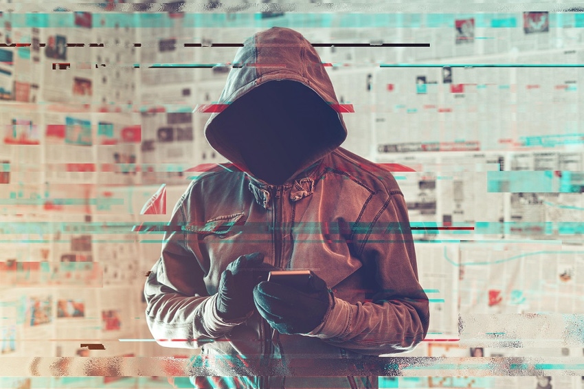 Hooded person with a newspaper backdrop