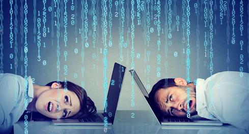 A man and a woman with their heads on the keyboards of their individual laptops looking overwhelmed A man and a woman with their heads on the keyboards of their individual laptops looking overwhelmed