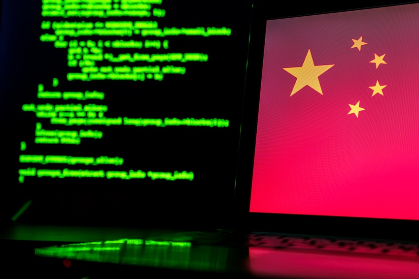 Chinese flag on a monitor with green code running on a screen in the background