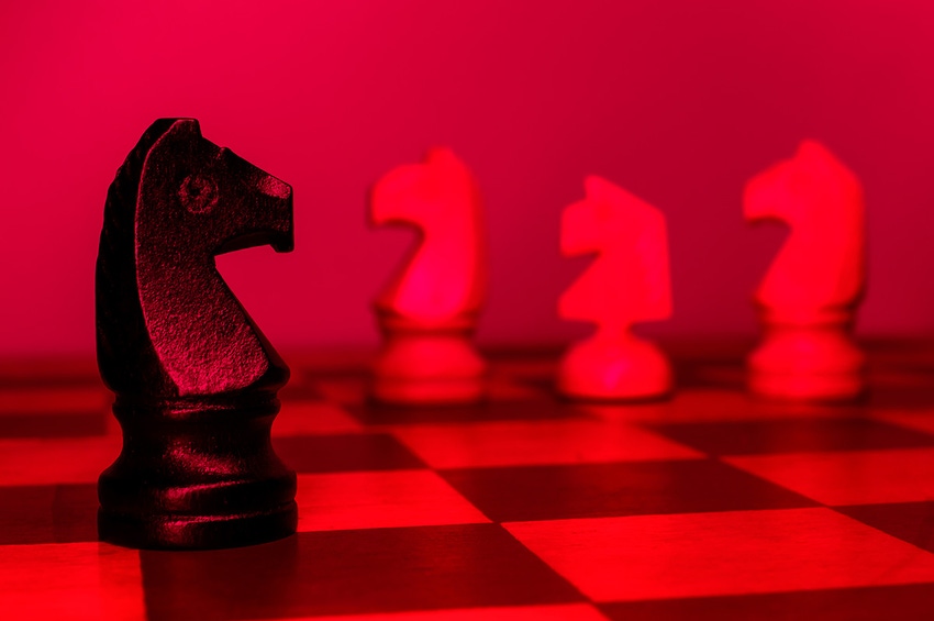 A black knight chess piece faces off against three white pieces