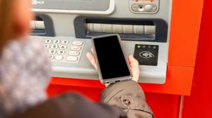 Individual transacting with ATM via NFC enabled phone Individual transacting with ATM via NFC enabled phone