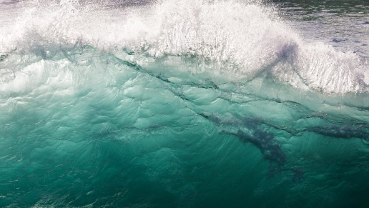 白い泡を伴って波が崩れる青緑色の海 白い泡を伴って波が崩れる青緑色の海