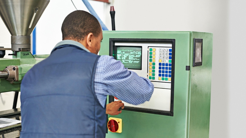All systems are ready: a man working over digital control panel of factory machinery.